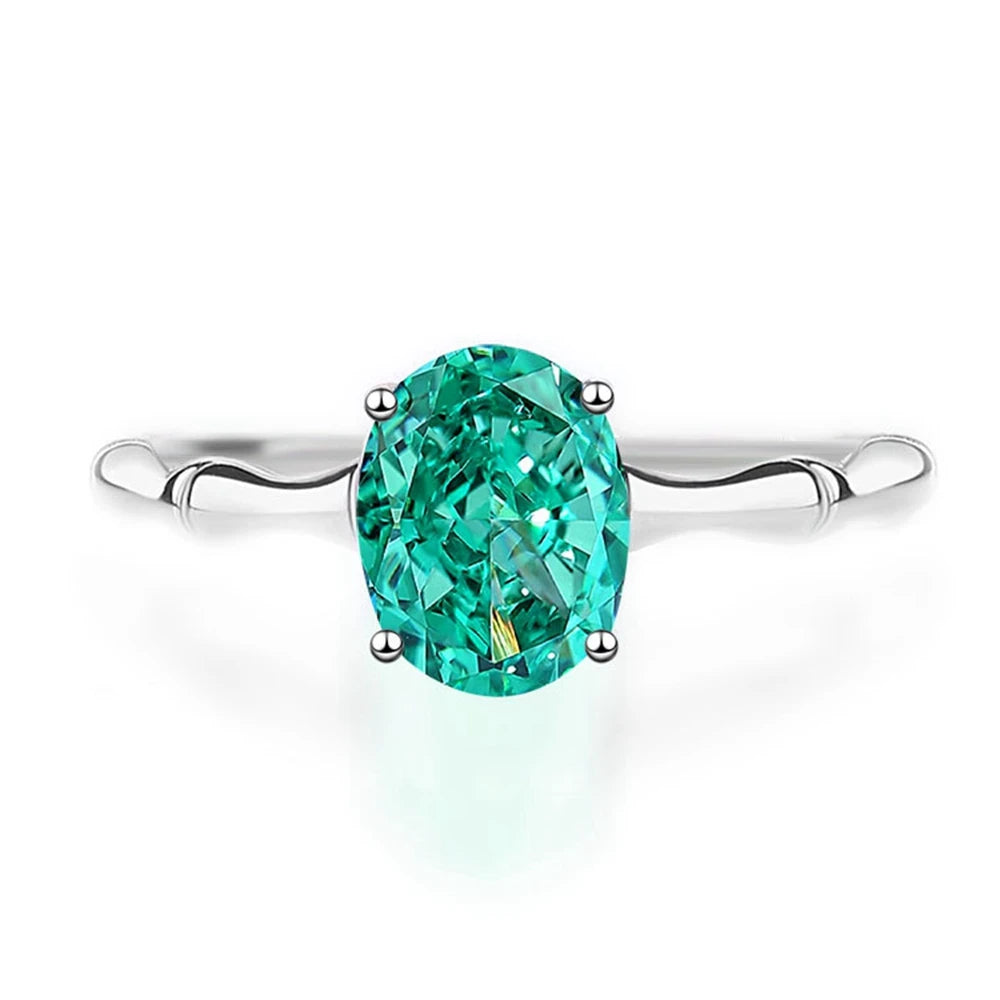 Green oval-cut gemstone ring with a polished silver band and four-prong setting