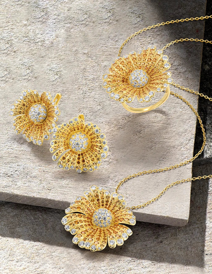 Gold-toned jewelry set with large daisy-like floral designs fully encrusted with clear crystals