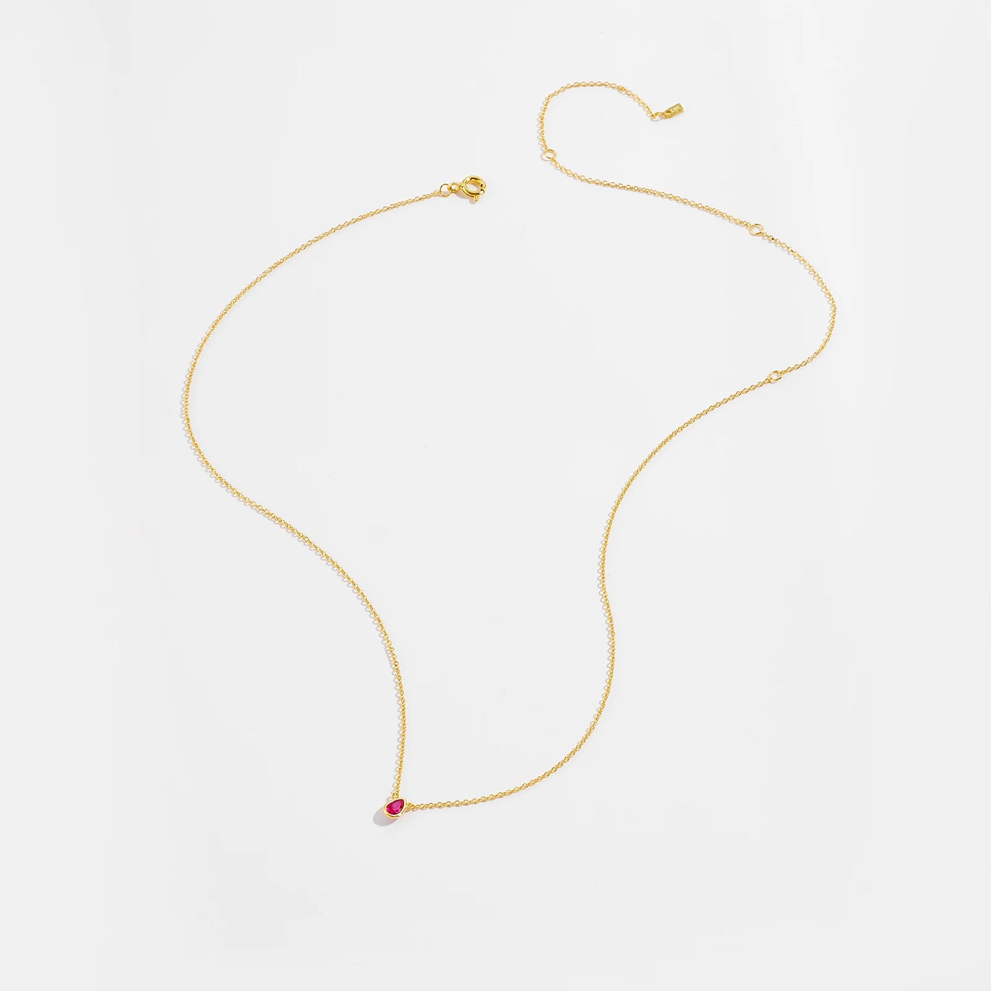 Gold necklace with a pear-shaped pink gemstone pendant at the center.