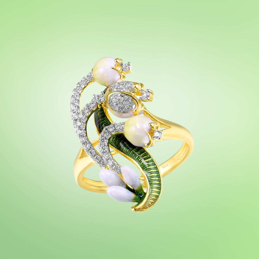 Gold ring with enamelled green leaves, pearl-like buds, and curved pavé-set crystal stems in a nature-inspired design