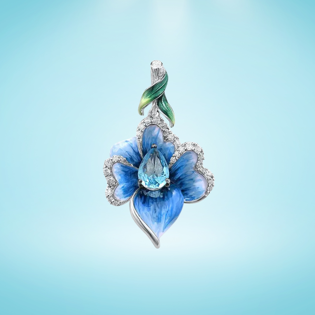 Floral silver pendant with hand-painted blue enamel petals, a teardrop-shaped aquamarine gemstone center, and a green enamel leaf accent