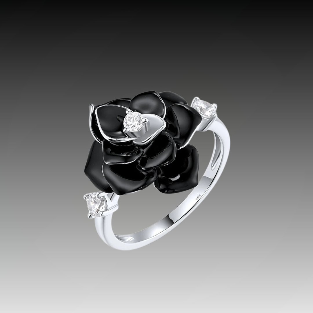 Silver ring with a black enamel rose centerpiece and two clear gemstones on the band.