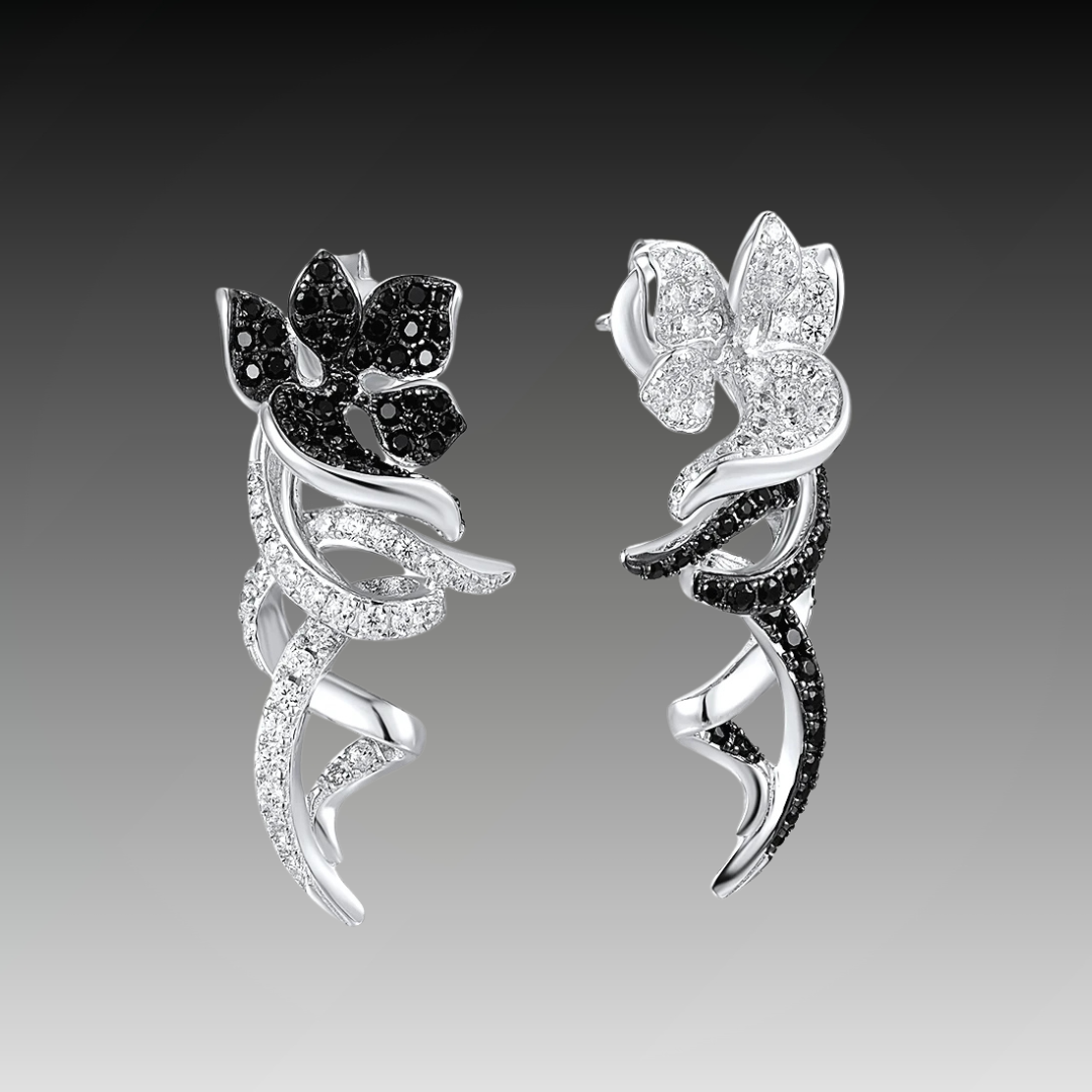 Asymmetric silver earrings with black and white floral designs and pavé details
