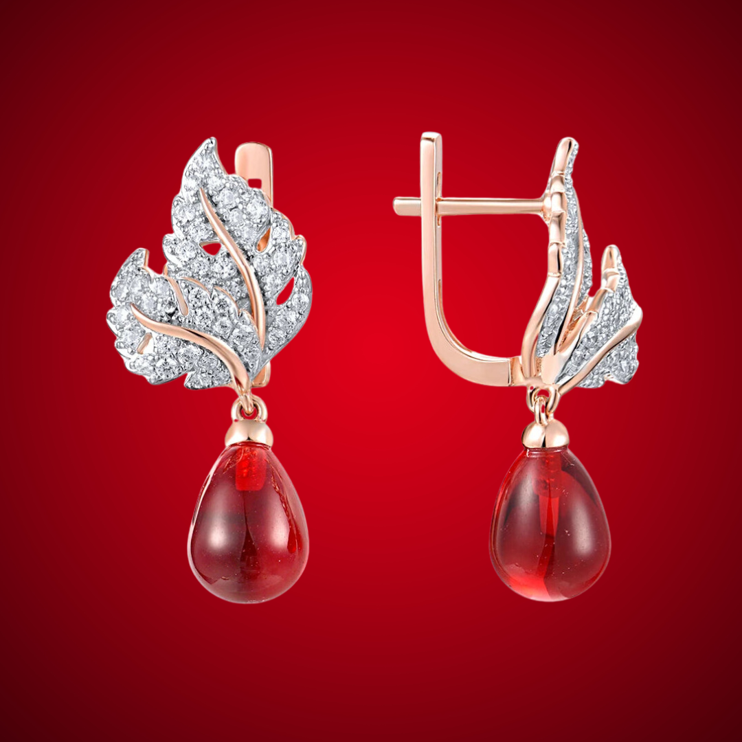 Lapino earrings with crystal-paved silver-tone leaves and rich red teardrop gemstone drops.