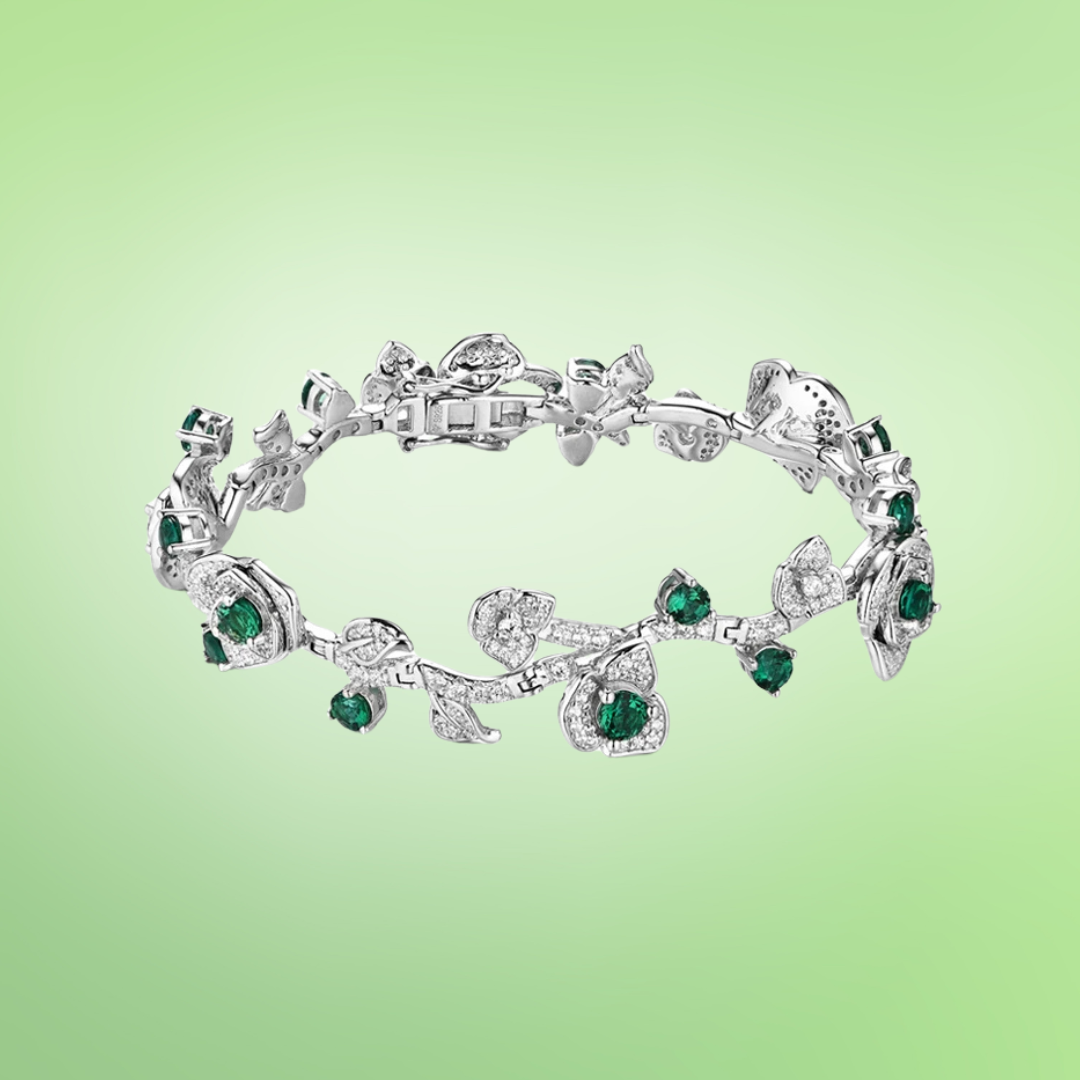 Silver bracelet with green stones and leafy vine design