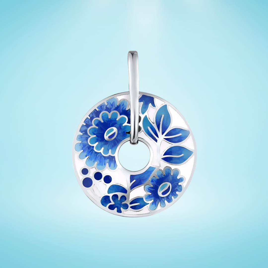 Sterling silver circular pendant with floral blue enamel designs and a central open circle, featuring stylized flowers and leaves