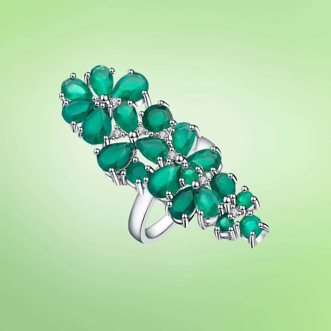 Long silver ring featuring clustered green teardrop-shaped stones arranged in floral formations