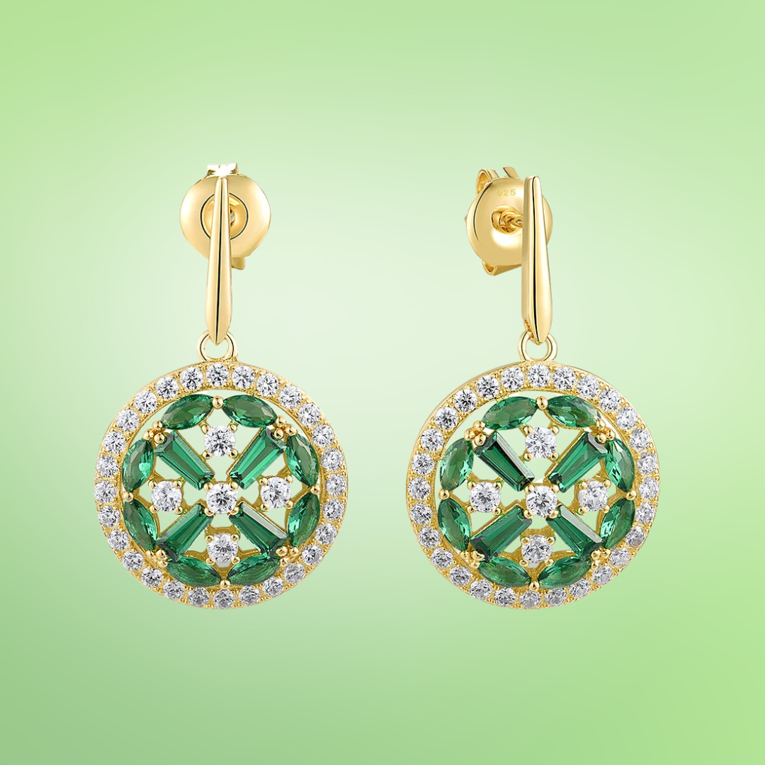 Gold drop earrings with circular design featuring green marquise and baguette stones surrounded by clear pavé accents