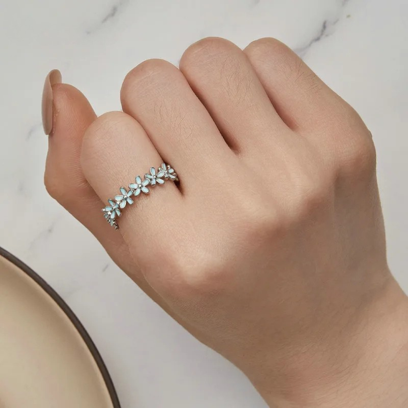 Silver floral band ring with alternating blue enamel and plain silver daisy motifs