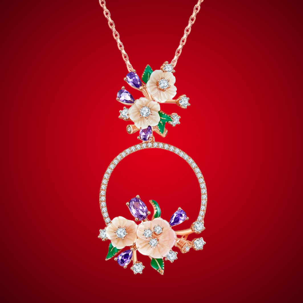 Infiorescenza necklace with a circular pendant adorned with peach flowers, violet gemstones, green enamel leaves, and sparkling white accents.