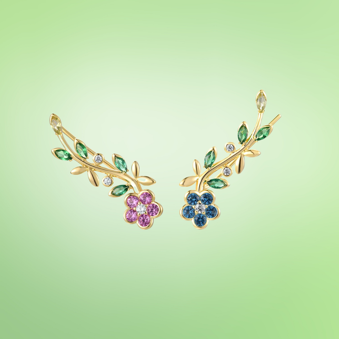 Gold earrings with pink and blue crystal flowers and green vine-like leaves

