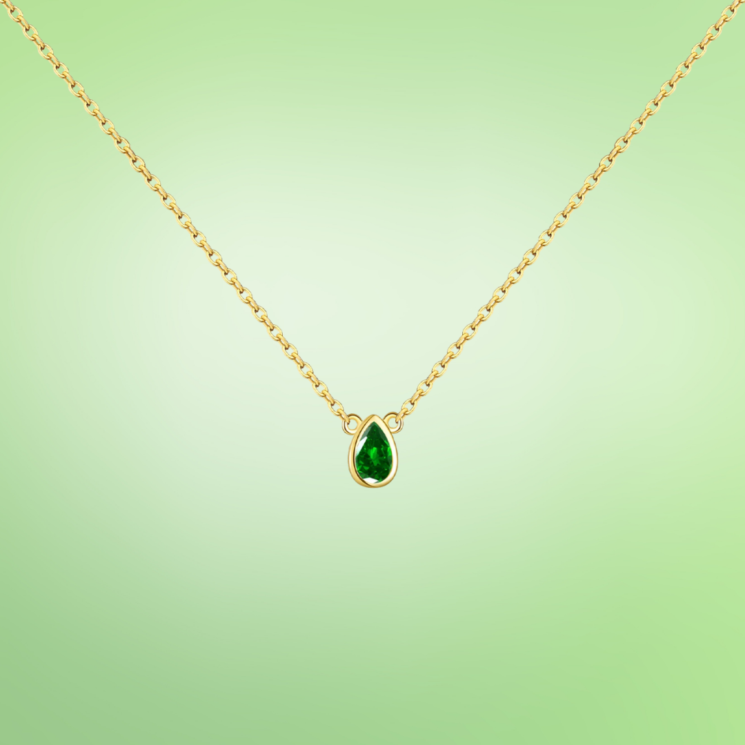 Delicate gold necklace featuring a teardrop-shaped green gemstone pendant.

