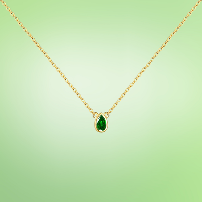 Delicate gold necklace featuring a teardrop-shaped green gemstone pendant.

