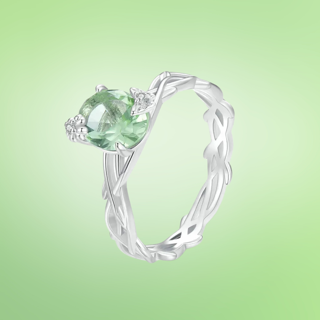Silver ring with green round gemstone and vine-inspired band design

