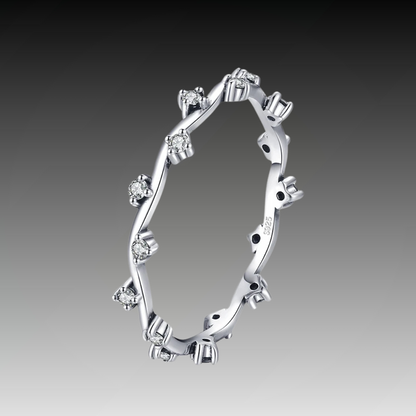 Delicate silver ring with twisting vine-like structure and small clear stones

