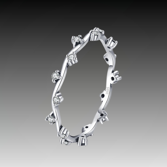 Delicate silver ring with twisting vine-like structure and small clear stones


