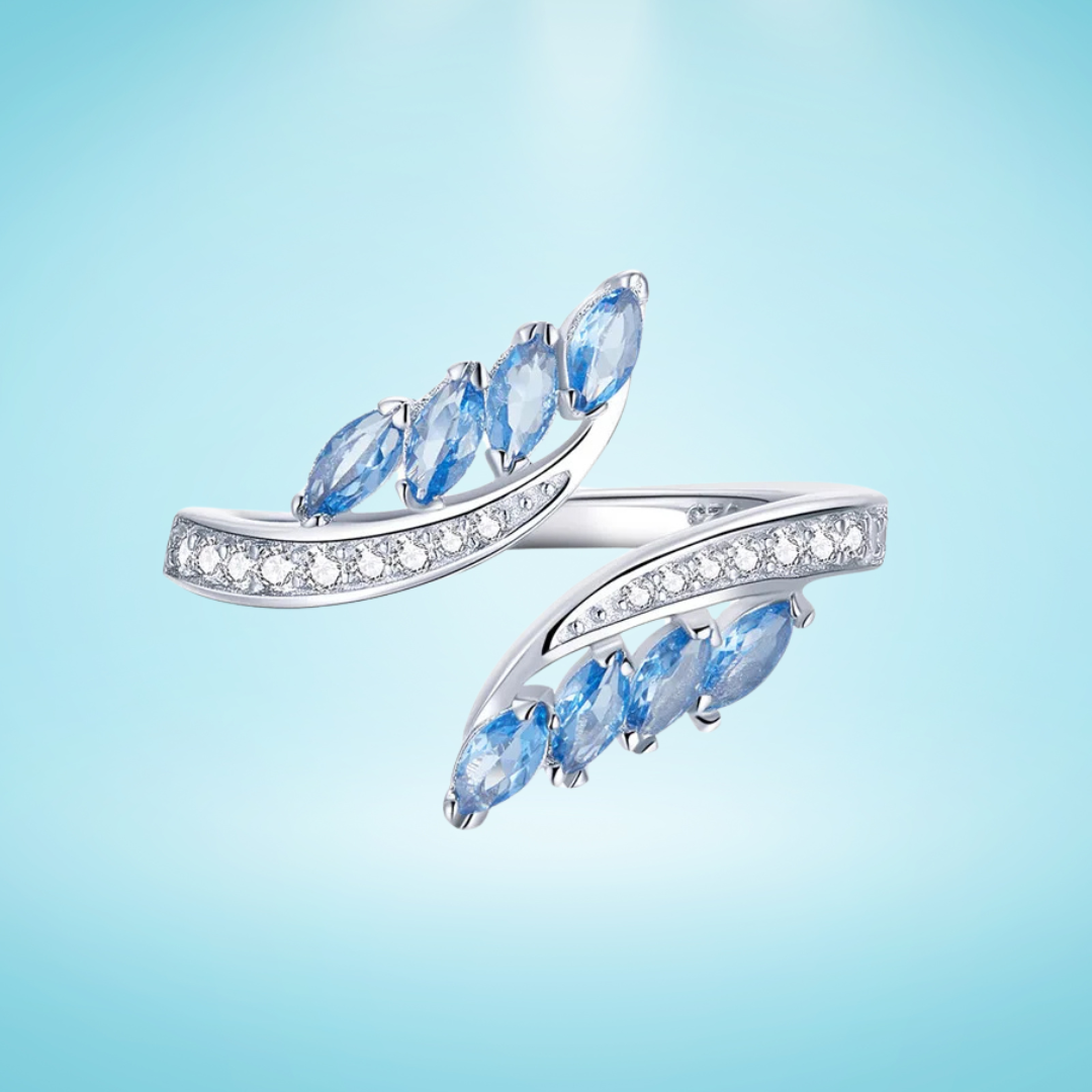 Silver ring featuring marquise-cut blue stones and a row of white cubic zirconia.

