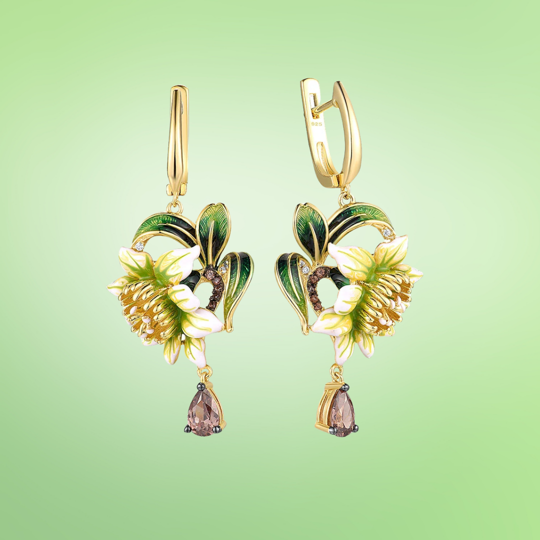 Gold drop earrings featuring white enamel flowers, green leaf detailing, and teardrop gemstones

