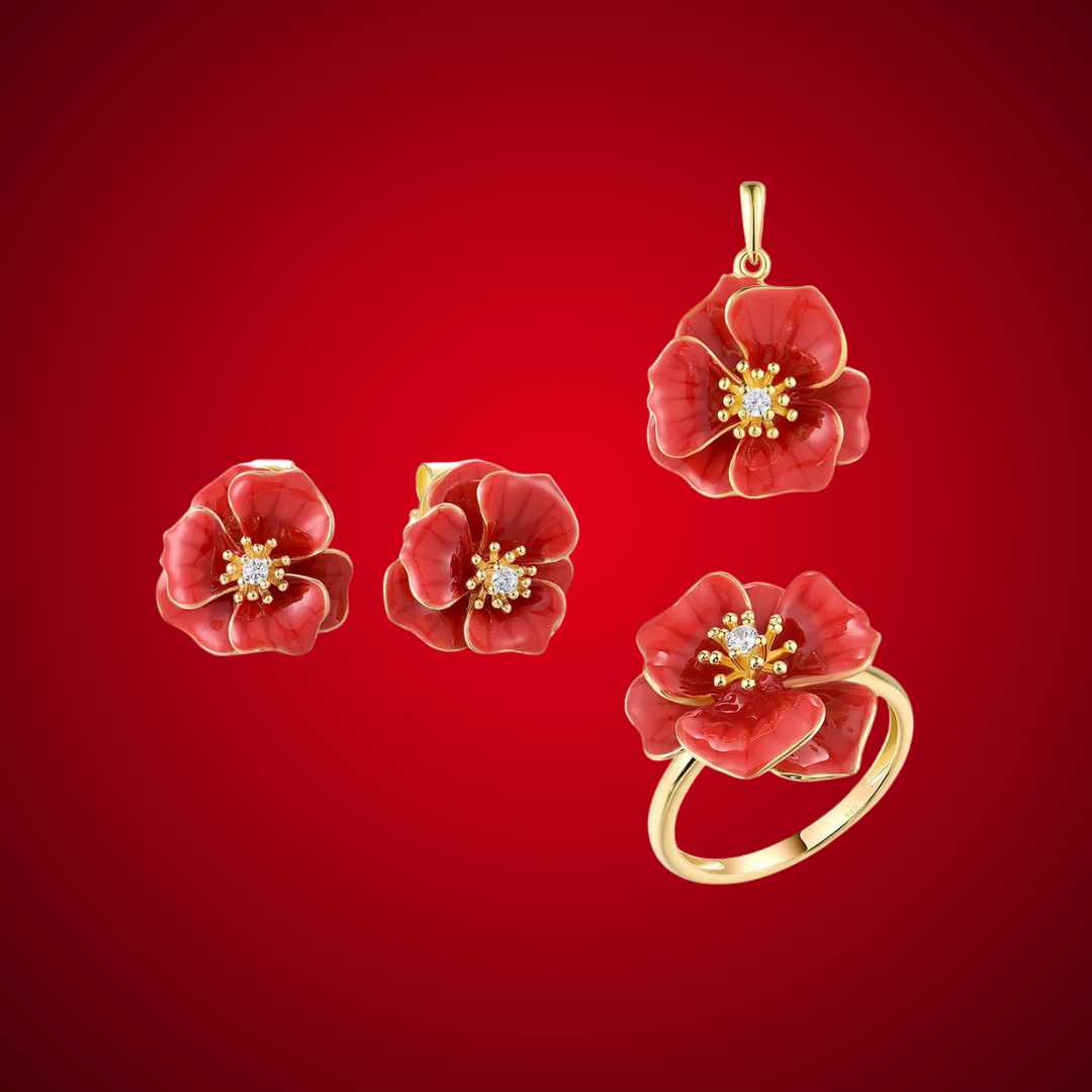 Jewelry set from the Rossa Collection featuring red enamel flower-shaped earrings, pendant, and ring with gold-tone detailing and central white stones.

