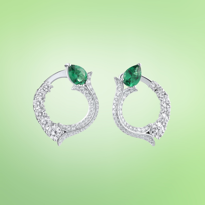 Silver earrings with circular diamond pave design and pear-shaped green jade stones at the top

