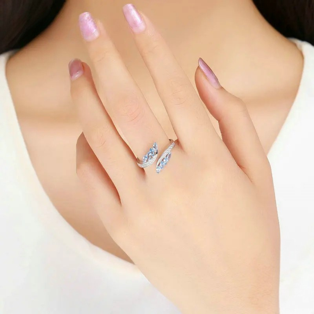 Silver ring featuring marquise-cut blue stones and a row of white cubic zirconia.

