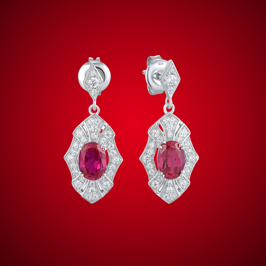 Rubino earrings with deep red oval stones framed in intricate silver settings accented by small white crystals.


