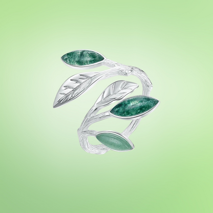Adjustable silver ring featuring green marbled leaf accents in an open branch design.


