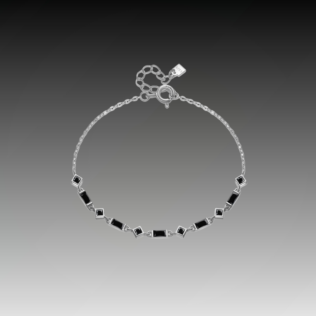 Silver bracelet with alternating square and rectangular black stones on a fine chain, from the Vindemia line.

