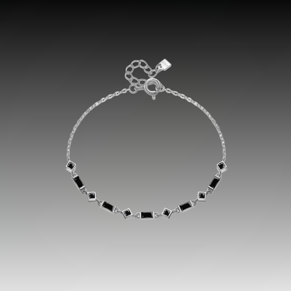 Silver bracelet with alternating square and rectangular black stones on a fine chain, from the Vindemia line.

