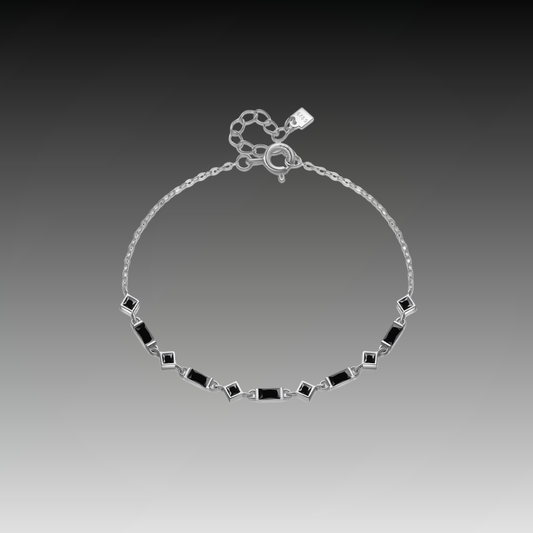 Silver bracelet with alternating square and rectangular black stones on a fine chain, from the Vindemia line.

