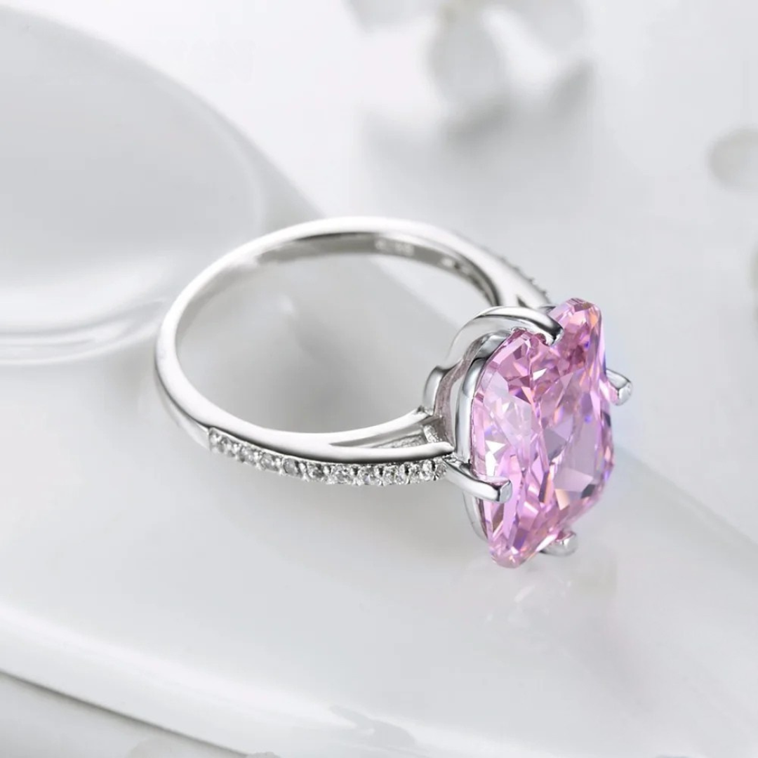 Sterling silver ring with a large rectangular-cut pink gemstone and pavé-set accents along the band.

