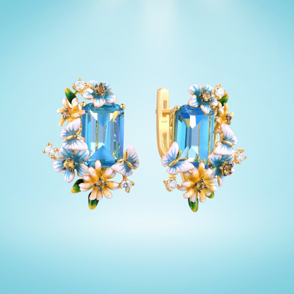 Gold floral earrings with large blue emerald-cut stones and pastel enamel blossoms

