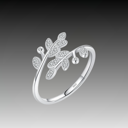 Silver ring designed with two curved branches, each adorned with pavé-set leaf shapes and tiny round white stones.

