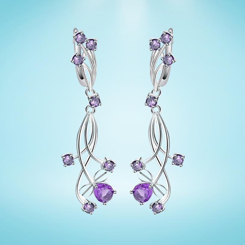 Sterling silver drop earrings shaped like violet enamel flowers with layered petals and small clear gemstones at the center