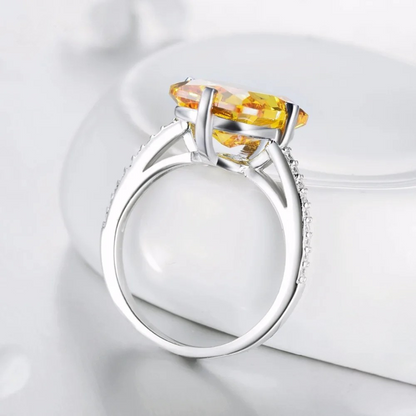 Silver ring with large rectangular yellow gemstone and pavé band detail

