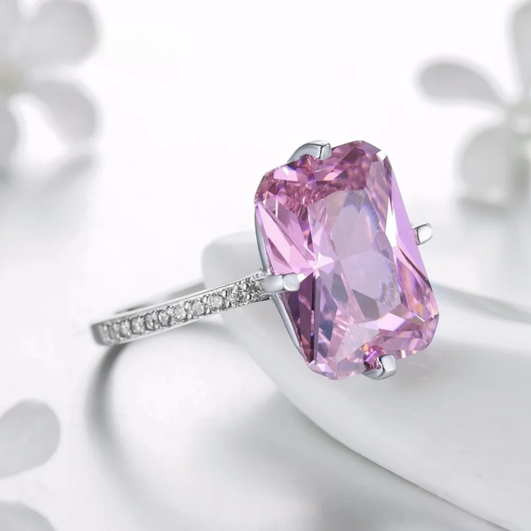 Sterling silver ring with a large rectangular-cut pink gemstone and pavé-set accents along the band.

