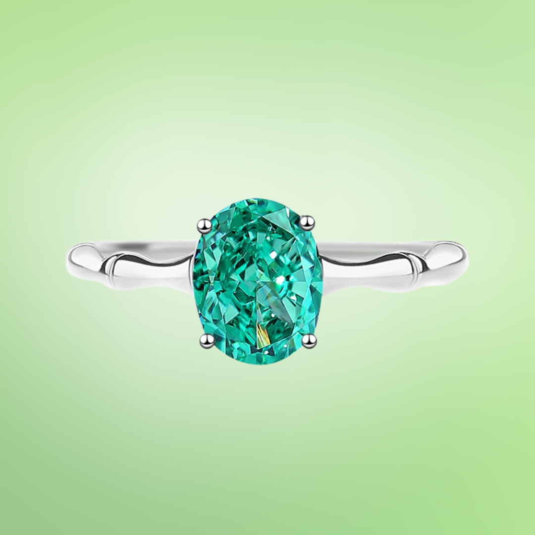 Green oval-cut gemstone ring with a polished silver band and four-prong setting

