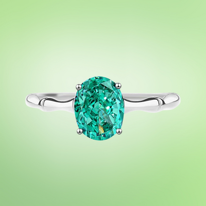 Green oval-cut gemstone ring with a polished silver band and four-prong setting

