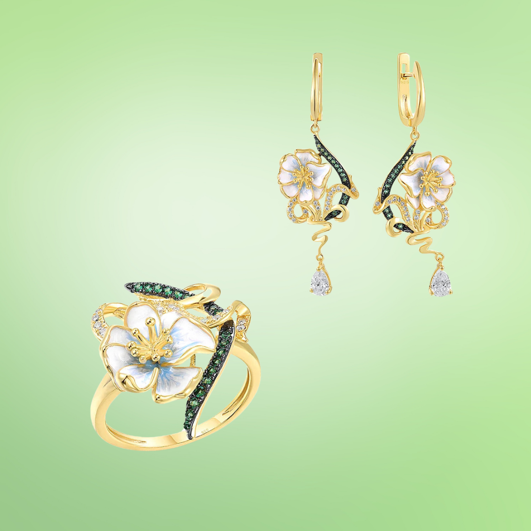 Gold ring and matching earrings with white enamel flowers, green stones, and swirling accents

