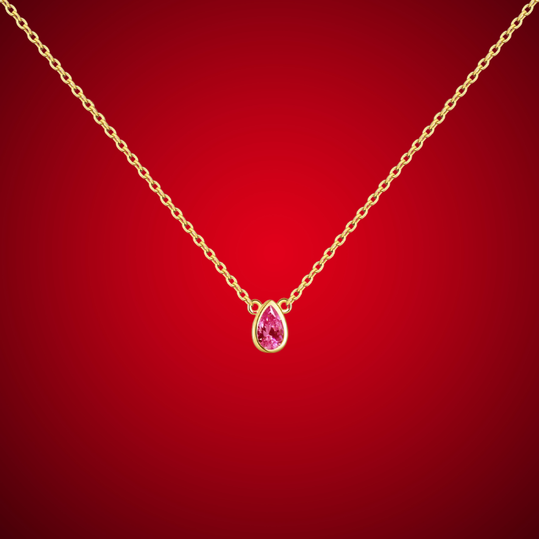 Gold necklace with a pear-shaped pink gemstone pendant at the center.

