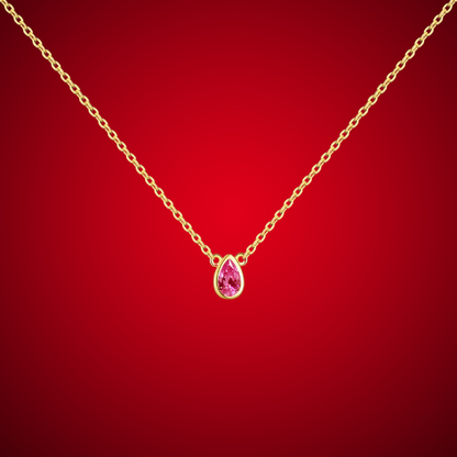 Gold necklace with a pear-shaped pink gemstone pendant at the center.

