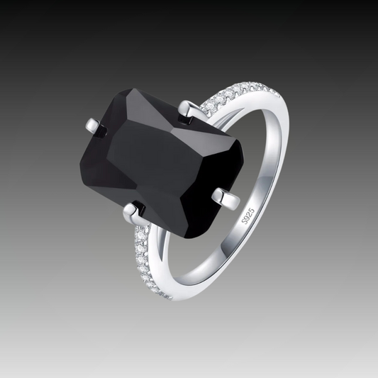 Silver ring with a large faceted black stone and pavé band

