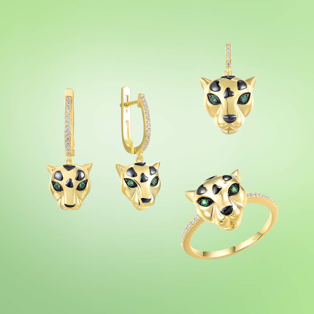 Gold jewelry set featuring panther heads with black spots and green eyes, including earrings, pendant, and ring

