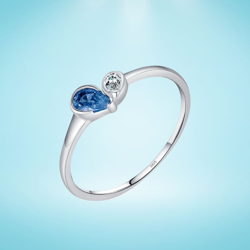 Sterling silver ring with a pear-shaped blue stone and round white stone set side by side

