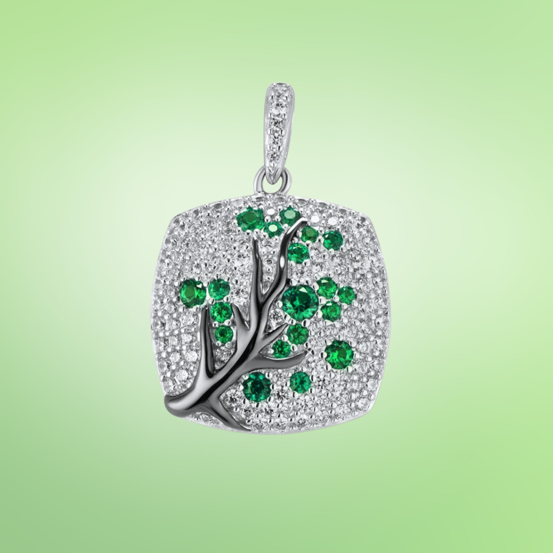 Silver square pendant featuring a black tree branch design with green gemstone leaves

