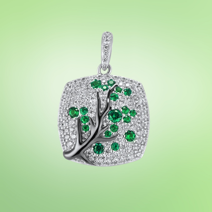 Silver square pendant featuring a black tree branch design with green gemstone leaves

