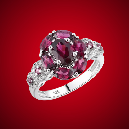 Silver ring featuring a bold cluster of deep red oval gemstones, framed by smaller accents, from the Rossa Collection.

