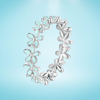 Silver floral band ring with alternating blue enamel and plain silver daisy motifs

