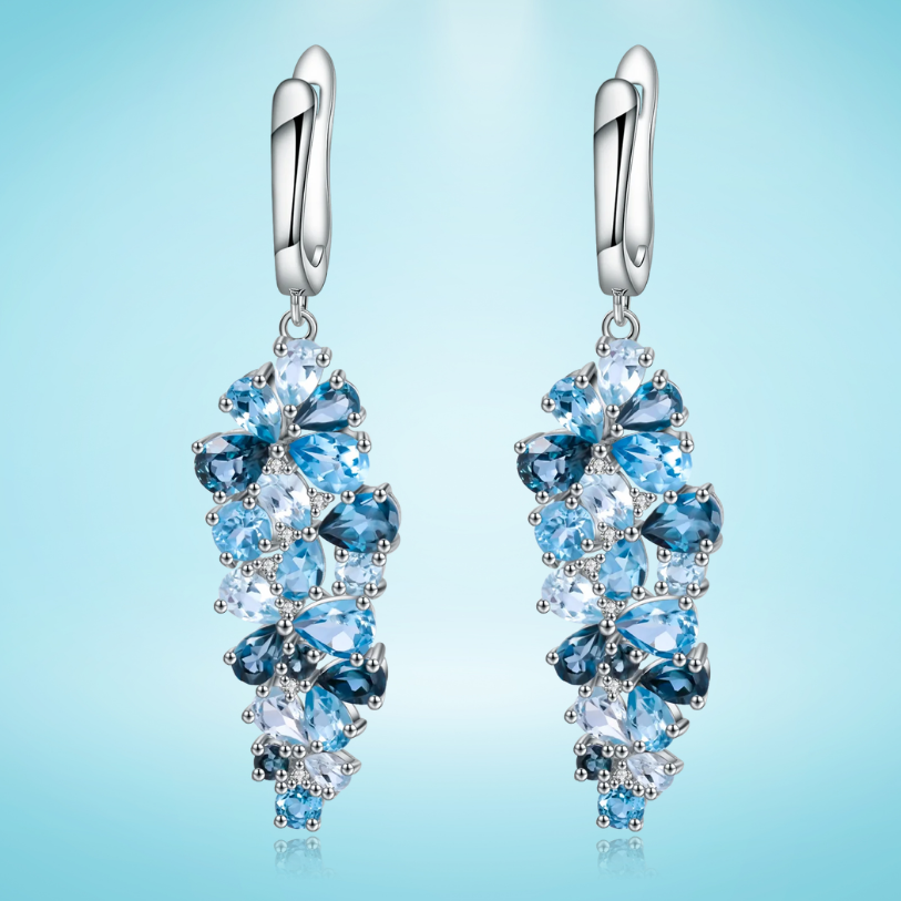 Silver drop earrings with clusters of marquise and pear-cut blue gemstones in varying shades

