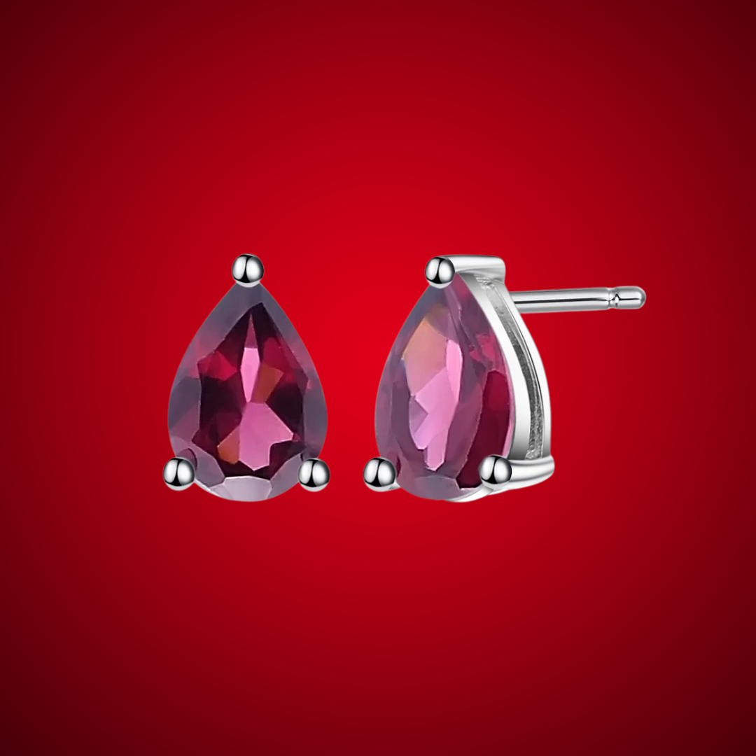 Pear-cut red gemstone stud earrings set in silver-tone prongs.

